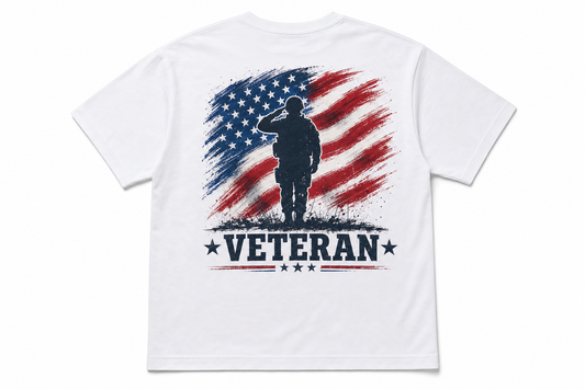 Back of white t-shirt laid flat on white background with veteran-themed red, white, and blue DTF print featuring flag and soldier graphic.